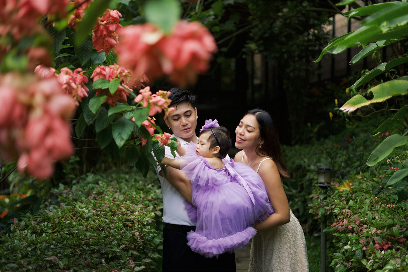 Giana with her parents framed by garden flowers